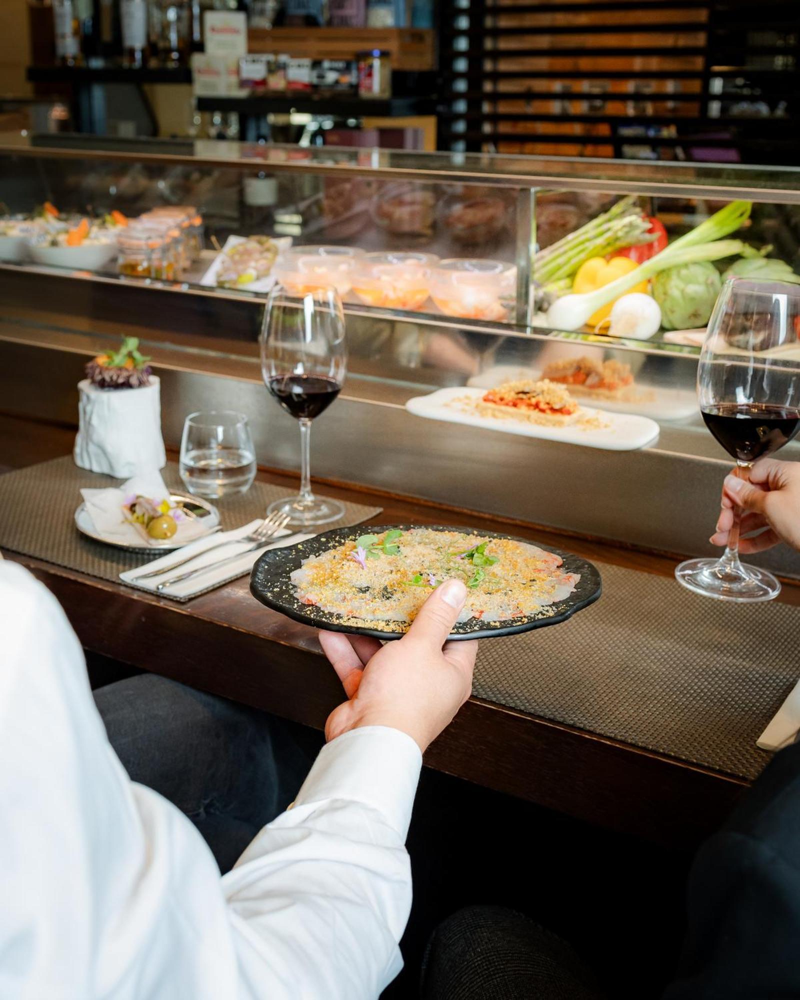 Hospes Amérigo Alicante Esterno foto A server delivers a plate of food to a customer